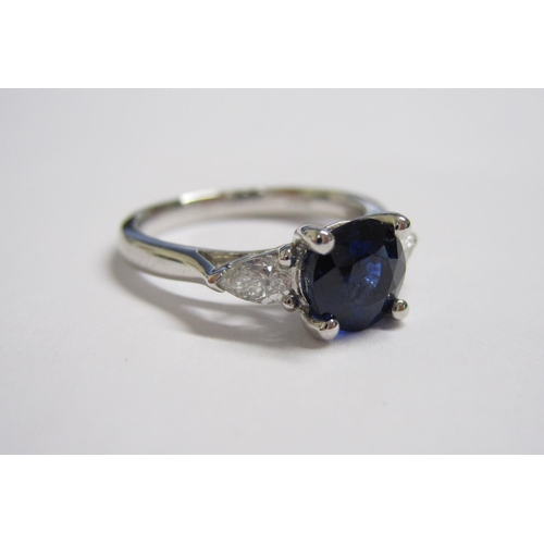 164 - A Sapphire and Diamond three stone Ring claw-set round sapphire, 1.53cts between two pear-cut diamon... 