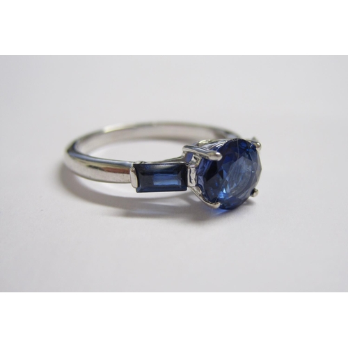 175 - A Sapphire three stone Ring claw-set round stone, 1.30cts, between two baguettes, ring size N.