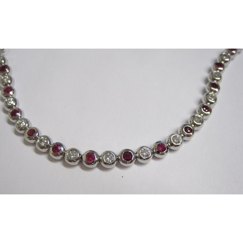 217 - A Diamond and Pink Sapphire Tennis Bracelet Set alternating brilliant-cut diamonds and round sapphir... 