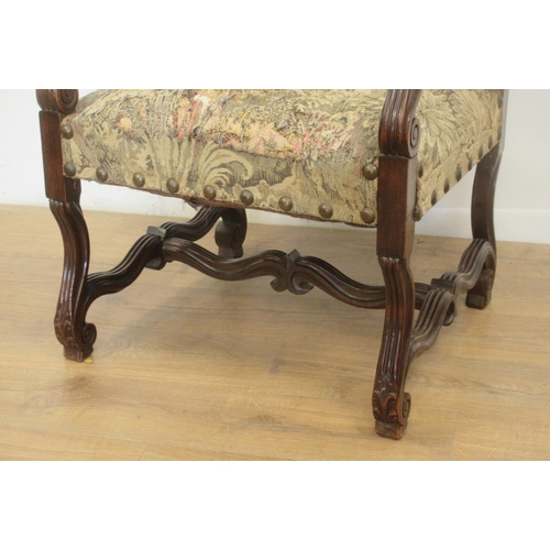 127 - A large carved Elbow Chair with tapestry back and seat on shaped and scrolled supports