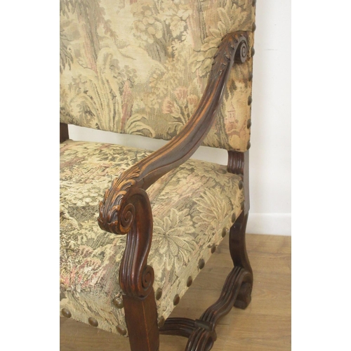 127 - A large carved Elbow Chair with tapestry back and seat on shaped and scrolled supports