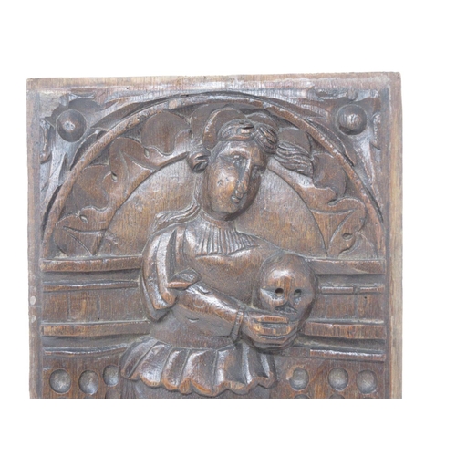 139 - A 17th Century carved oak Panel of a female Saint with skull 14 1/2in x 8 1/2in