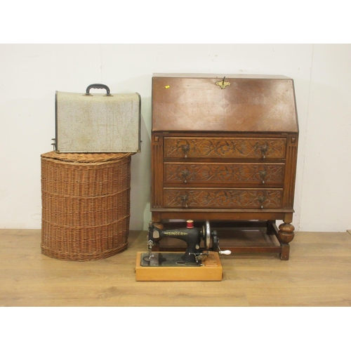 52 - An oak Bureau, a cane corner Linen Basket and a Singer Sewing Machine in case
