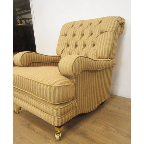 73 - A pair of Kirkdale button upholstered Armchairs with striped gold upholstery on brass front casters,... 