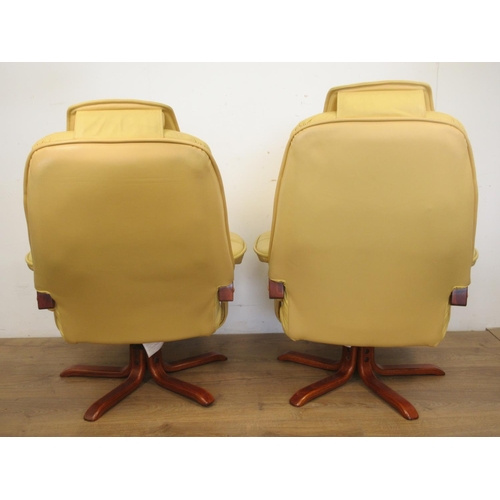 82 - A pair of yellow leather/leather effect swivel Armchairs.