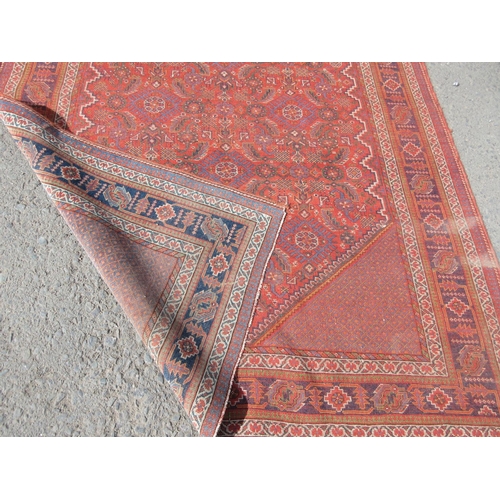 667 - A red ground Rug with stylised leafage design within tramline borders 6ft 3in x 4ft 6in and a half r... 