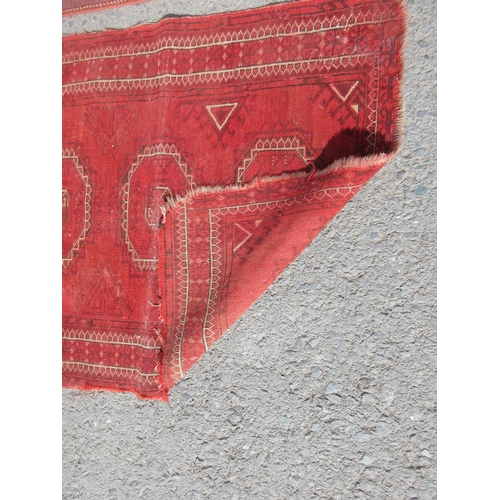 667 - A red ground Rug with stylised leafage design within tramline borders 6ft 3in x 4ft 6in and a half r... 