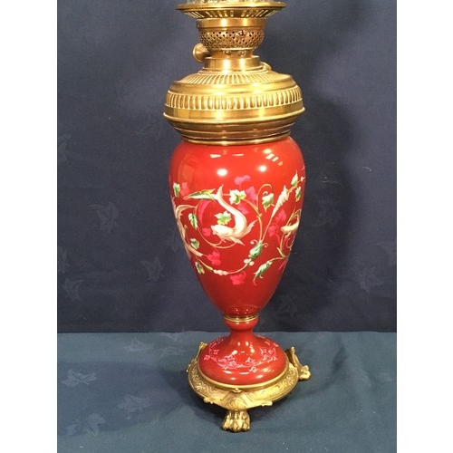 149 - An Oil Lamp with glass shade and brass reservoir mounted within a deep red ground porcelain baluster... 