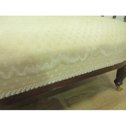 129 - A Victorian rosewood and inlaid Sofa with cream upholstery and fluted spindle back mounted upon balu... 