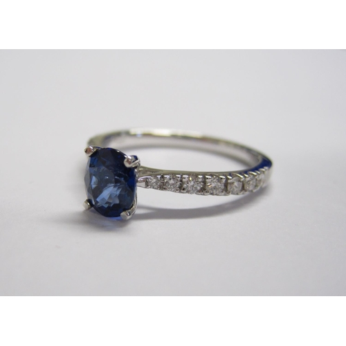 168 - A Sapphire and Diamond Ring claw-set oval-cut sapphire, 0.91cts, between graduated brilliant-cut dia... 