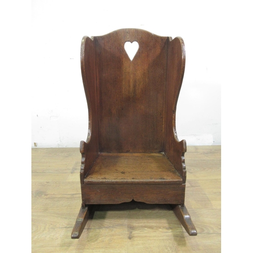 549 - An 18th Century oak wing backed child's Rocking Chair with pierced heart to back panel 2ft 1in H x 1... 