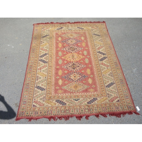 659 - A red and cream Rug with geometric multi borders 8ft 6in L x 6ft 4in W