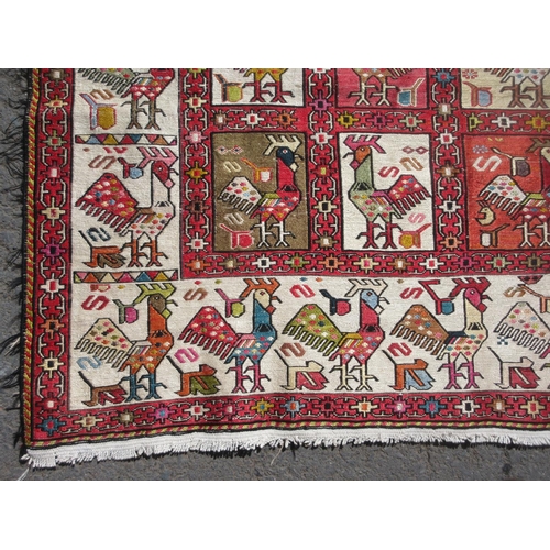 652 - A cream ground Rug with geometric border and stylised cockerel designs 6ft 10in x 4ft 2in