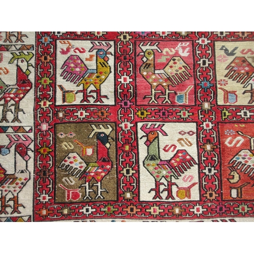 652 - A cream ground Rug with geometric border and stylised cockerel designs 6ft 10in x 4ft 2in