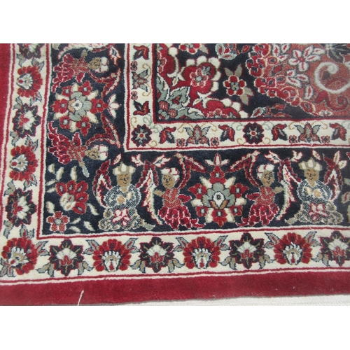 653 - A Turkish red ground Rug with design of figures on horseback and large central motif within multiple... 