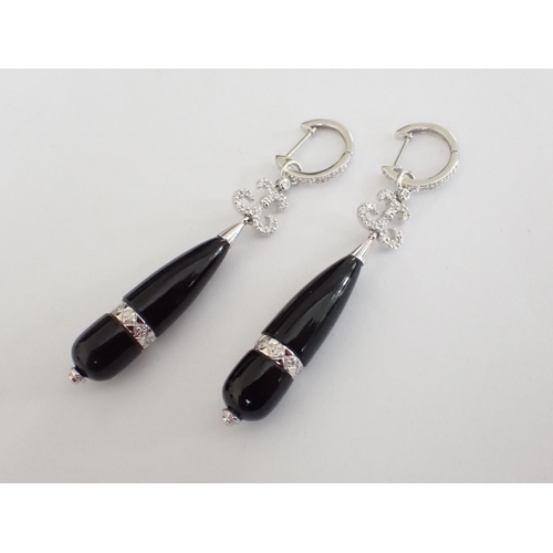 124 - A pair of Art Deco style Diamond and Black Onyx Ear Pendants, each with scroll mount pavé-set brilli... 