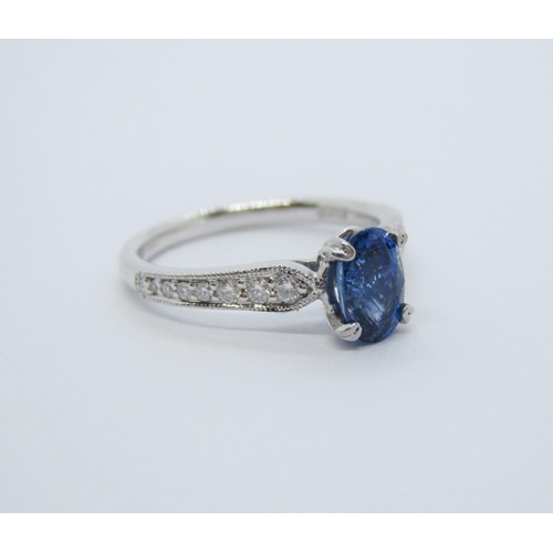 126 - A Sapphire and Diamond Ring, claw-set oval mixed-cut sapphire, 0.96cts, between graduated brilliant-... 