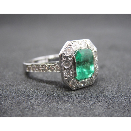 127 - An Art Deco style Emerald and Diamond Ring set step-cut emerald, 1.27cts, within a frame of pavé-set... 