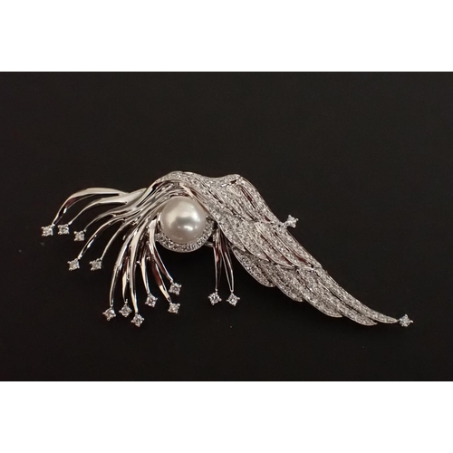 148 - A Cultured Pearl and Diamond Brooch the asymmetric plaque set pearl among numerous brilliant-cut dia... 