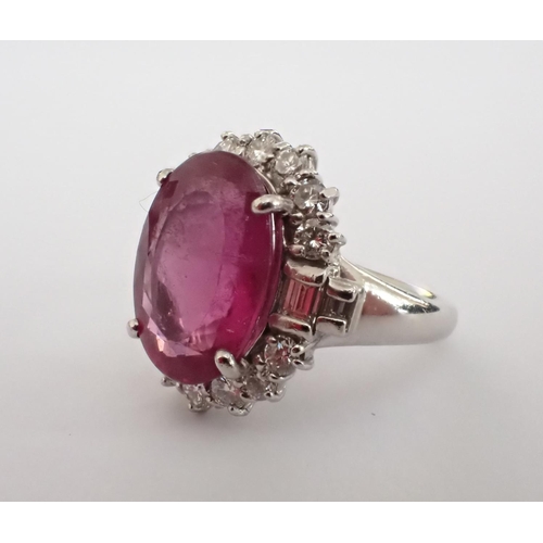 155 - A Pink Tourmaline and Diamond Cluster Ring claw-set oval-cut tourmaline, 6.05cts, within a frame of ... 