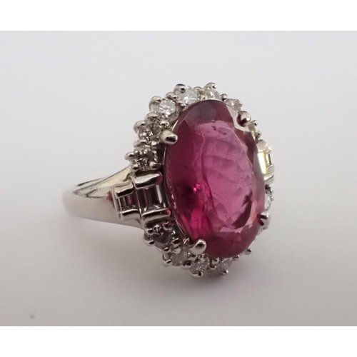 155 - A Pink Tourmaline and Diamond Cluster Ring claw-set oval-cut tourmaline, 6.05cts, within a frame of ... 