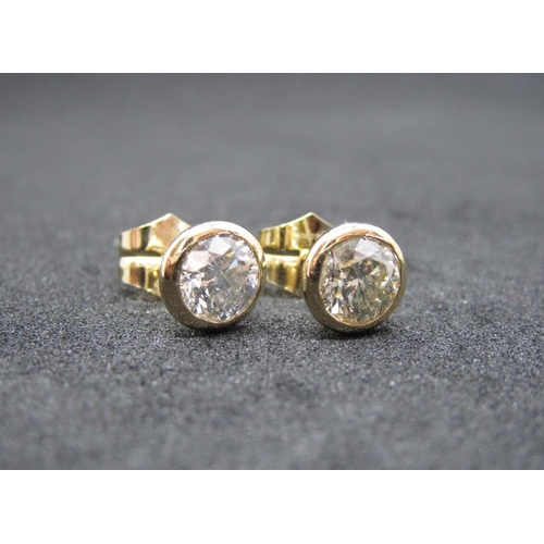 167 - A pair of Diamond Ear Studs, each rubover-set brilliant-cut stone, total diamond weight 1.75cts, in ... 