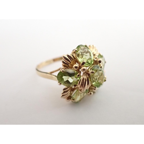 172 - A flowerhead Peridot Ring claw-set six oval-cut stones in 9ct gold, ring size S