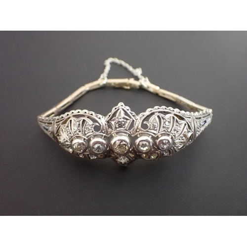 185 - An Edwardian Diamond and Sapphire Bracelet having domed shaped pierced front millegrain-set numerous... 