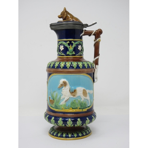 257 - A George Jones majolica Jug with hinged lid with fox finial, the handle moulded as a whip, two panel... 