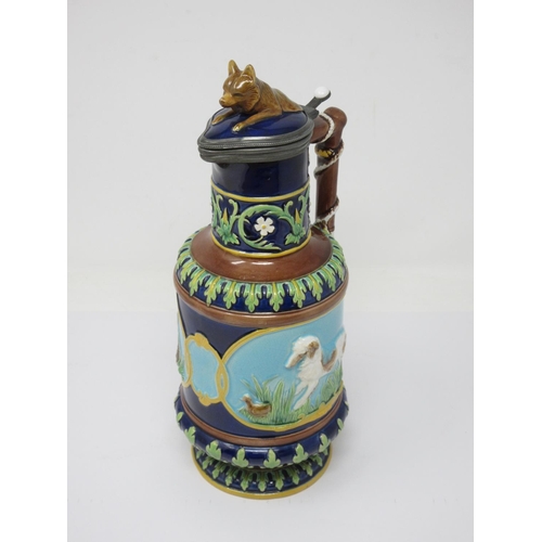 257 - A George Jones majolica Jug with hinged lid with fox finial, the handle moulded as a whip, two panel... 