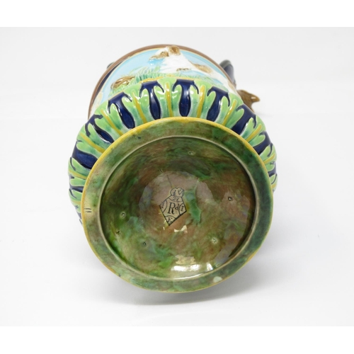 257 - A George Jones majolica Jug with hinged lid with fox finial, the handle moulded as a whip, two panel... 