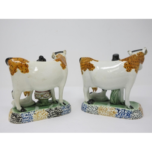 294 - A pair of early 19th Century pottery Cow and Calf with cowman and milk maid Figures on oblong bases,... 