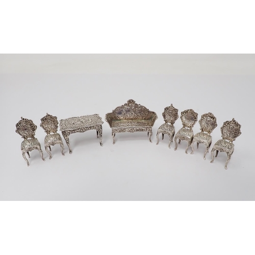 38 - A Victorian Continental silver miniature Table, Settee and six Chairs, decorated figures, scroll, et... 