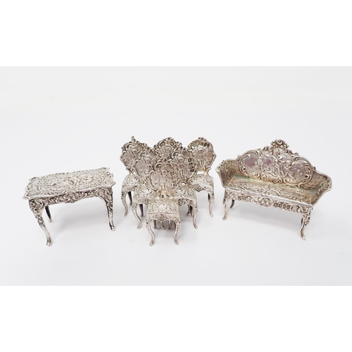 38 - A Victorian Continental silver miniature Table, Settee and six Chairs, decorated figures, scroll, et... 