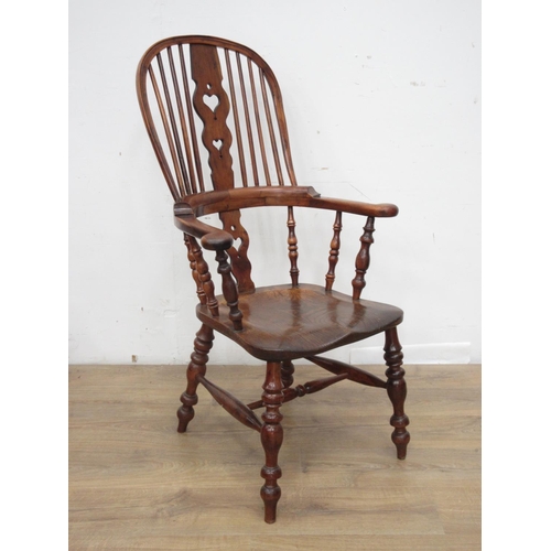 439 - A near pair of early 19th Century elm and yew wood broad arm Windsor Chairs with pierced heart splat... 