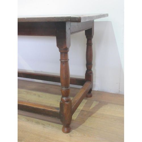 451 - An 18th Century oak Dining Table, the three plank cleated top above a moulded freize on turned legs ... 