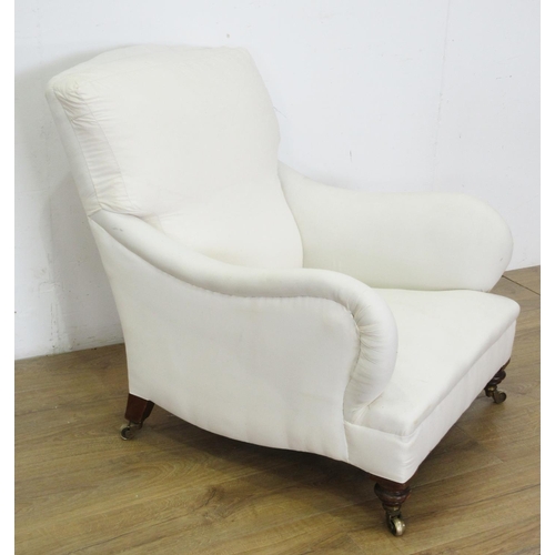 454 - A Victorian Howard style Armchair the cushion back and shaped arms above a deep seat, raised on turn... 