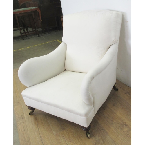 454 - A Victorian Howard style Armchair the cushion back and shaped arms above a deep seat, raised on turn... 