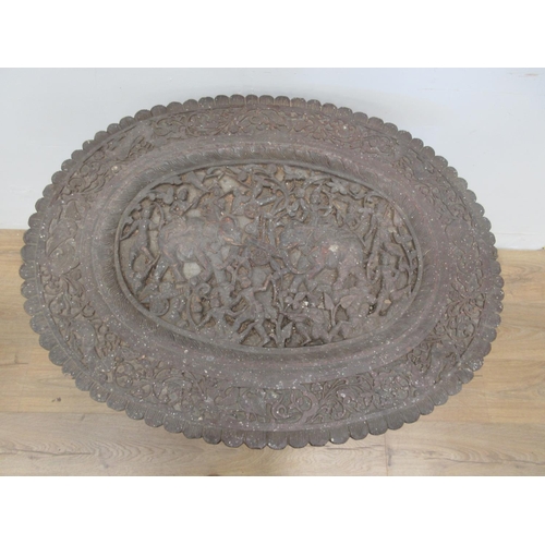 463 - An unusual 19th Century Indian Table, the oval top carved elephants and numerous figures on four dra... 