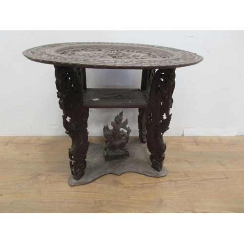 463 - An unusual 19th Century Indian Table, the oval top carved elephants and numerous figures on four dra... 