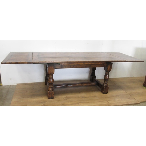 481 - An oak drawleaf Dining Table in the 18th Century style with cleated top on baluster supports and squ... 