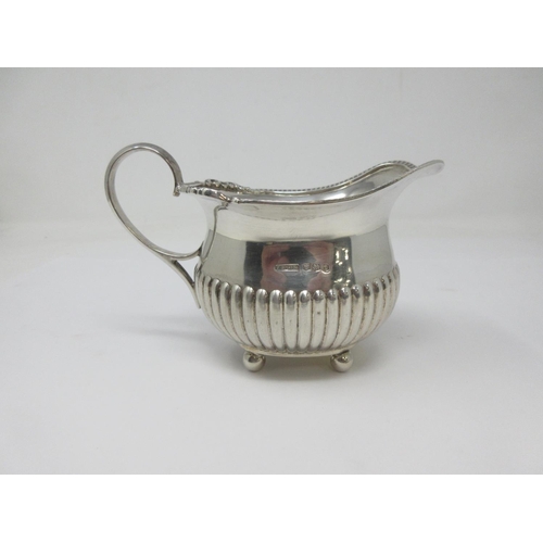 5 - An Edward VIII silver boat shape Jug of semi-fluted form on ball feet, Sheffield 1936, 146gms