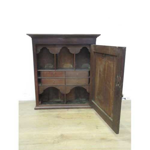 523 - An antique oak Spice Cupboard with single door enclosing a fitted interior of shelves and drawers, 3... 