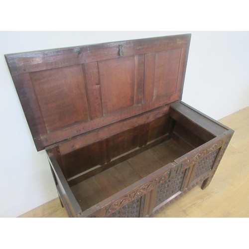 527 - A 17th Century carved oak Coffer, the panelled lid above a lunette frieze and three scroll carved pa... 