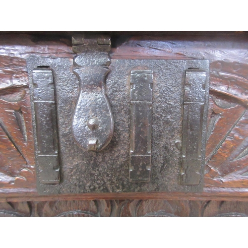 527 - A 17th Century carved oak Coffer, the panelled lid above a lunette frieze and three scroll carved pa... 