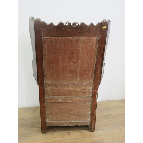 532 - An antique oak Lambing Chair with shaped top rail, inset brass plaque inscribed W.Smith 1850, wing b... 