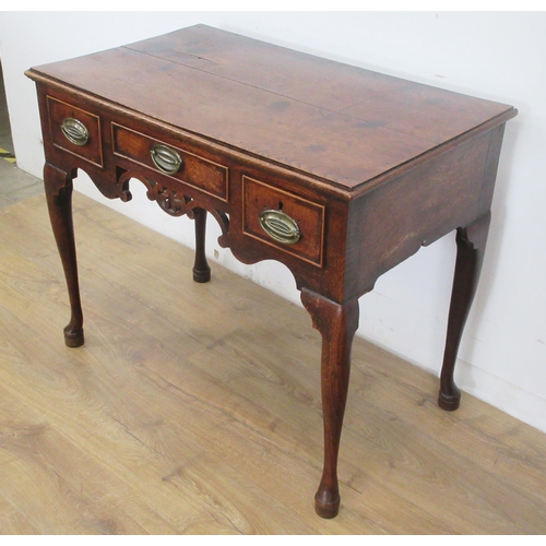 533 - An 18th Century oak Lowboy fitted three drawers above carved and pierced frieze on four cabriole leg... 