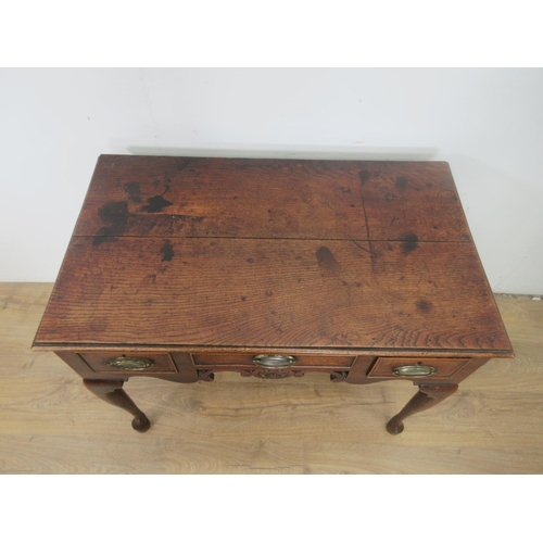 533 - An 18th Century oak Lowboy fitted three drawers above carved and pierced frieze on four cabriole leg... 