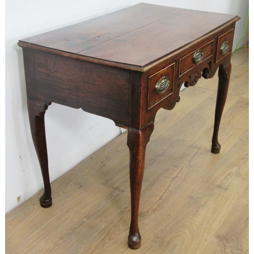 533 - An 18th Century oak Lowboy fitted three drawers above carved and pierced frieze on four cabriole leg... 