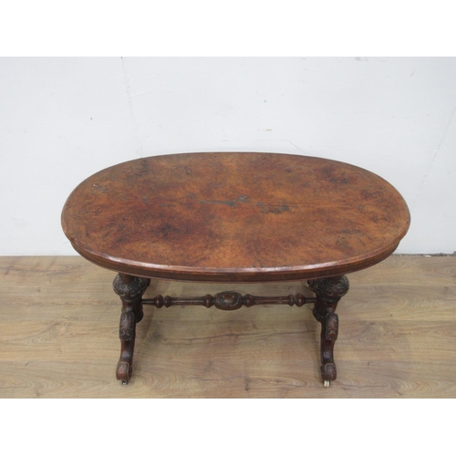 543 - A Victorian walnut Centre Table with oval top on carved cheval frame and stretcher and on casters, 3... 